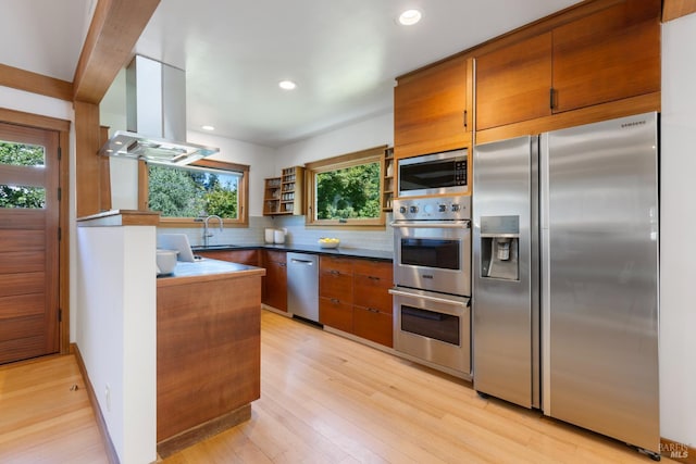 55 Durham Rd, San Anselmo, CA 94960 - kitchen featuring appliances with stainless steel finishes, island range hood, backsplash, light wood-style floors, and recessed lighting