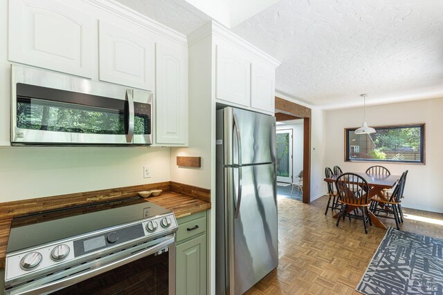 4011 Mill Creek Rd, Healdsburg, CA 95448 - kitchen featuring stainless steel appliances, wood counters, white cabinets, a textured ceiling, and hanging light fixtures