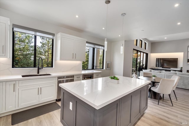 1994 W Bristlecone Ct, Santa Rosa, CA 95403 - kitchen featuring a sink, stainless steel dishwasher, a center island, light stone countertops, and light wood finished floors