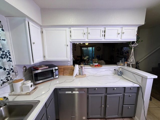 561 Samuel Way, Sacramento, CA 95838 - kitchen featuring stainless steel appliances, gray cabinetry, a peninsula, light stone counters, and white cabinetry