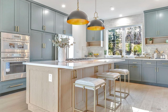 22 Cedar Ave, Kentfield, CA 94904 - kitchen with stainless steel double oven, backsplash, light countertops, a kitchen island, and light wood finished floors