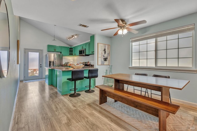 1753 15th St, San Pablo, CA 94806 - dining area with light wood-style flooring, vaulted ceiling, a ceiling fan, and baseboards