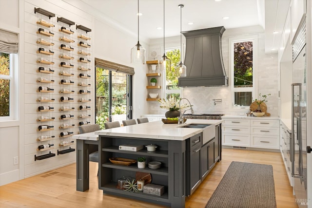 943 Appleridge Pl, Fairfield, CA 94534 - kitchen with open shelves, custom range hood, decorative backsplash, a kitchen island with sink, and recessed lighting
