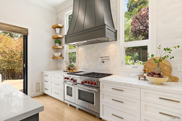 943 Appleridge Pl, Fairfield, CA 94534 - kitchen featuring custom exhaust hood, range with two ovens, decorative backsplash, open shelves, and light stone counters