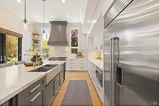 943 Appleridge Pl, Fairfield, CA 94534 - kitchen featuring built in appliances, custom exhaust hood, light stone counters, pendant lighting, and tasteful backsplash