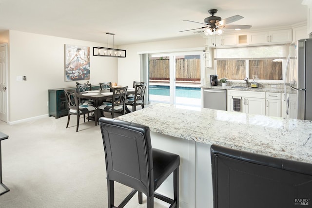 481 Chelsea Way, Fairfield, CA 94533 - kitchen with stainless steel appliances, white cabinetry, light stone counters, light colored carpet, and a ceiling fan