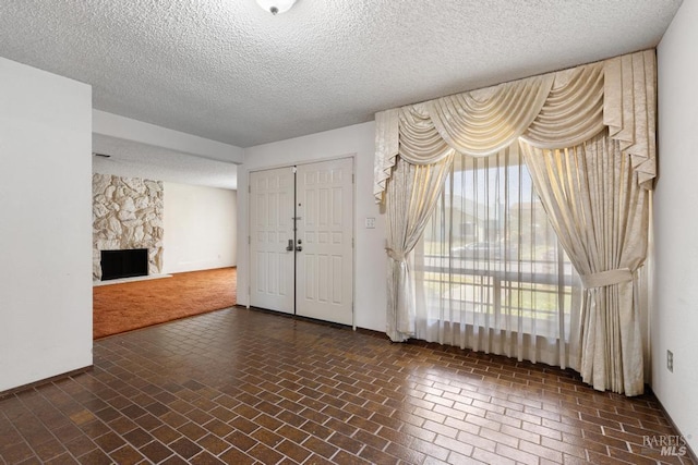 1417 Klamath Dr, Suisun City, CA 94585 - foyer with brick flooring, a textured ceiling, a stone fireplace, and baseboards
