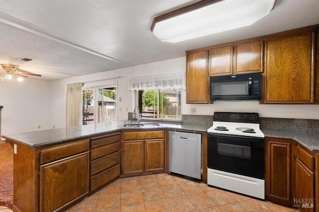 1417 Klamath Dr, Suisun City, CA 94585 - kitchen with electric range, black microwave, a sink, dishwasher, and brown cabinetry