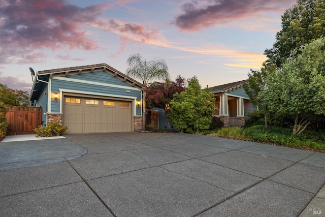 8596 Starr Rd, Windsor, CA 95492 - view of front facade with concrete driveway, an attached garage, a gate, and stone siding