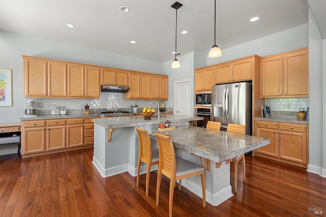 8596 Starr Rd, Windsor, CA 95492 - kitchen featuring stainless steel appliances, under cabinet range hood, dark wood finished floors, tasteful backsplash, and a kitchen bar