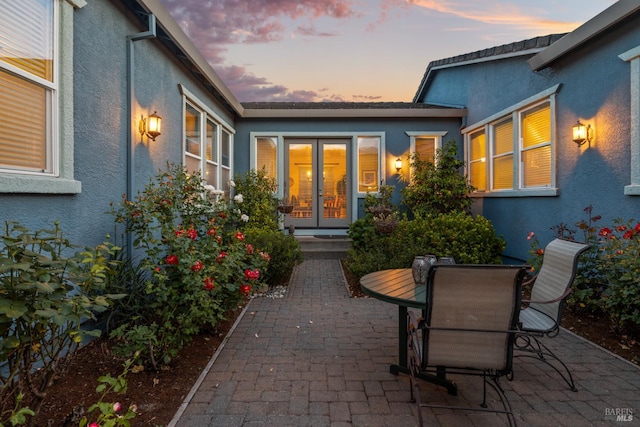 8596 Starr Rd, Windsor, CA 95492 - exterior entry at dusk with french doors, stucco siding, and a patio