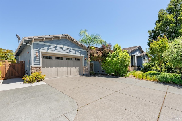 8596 Starr Rd, Windsor, CA 95492 - view of front facade with stone siding, an attached garage, concrete driveway, and a gate