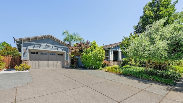 8596 Starr Rd, Windsor, CA 95492 - view of front of home featuring driveway, stone siding, an attached garage, and a gate