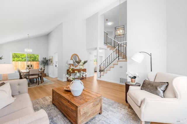 225 Riverview Dr, Vallejo, CA 94589 - living area with a chandelier, stairs, high vaulted ceiling, light wood-style flooring, and baseboards