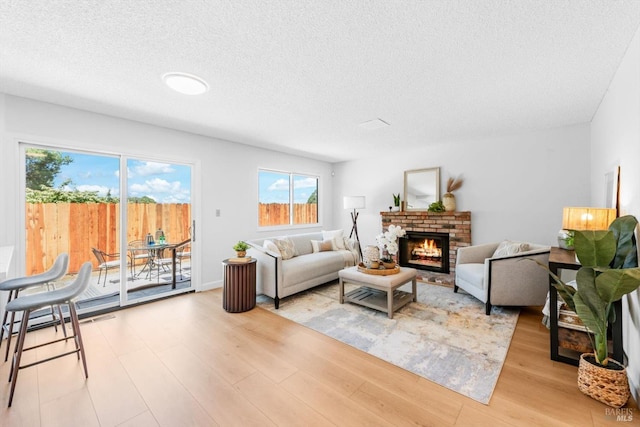 225 Riverview Dr, Vallejo, CA 94589 - living room featuring light wood-style flooring, a textured ceiling, and a brick fireplace