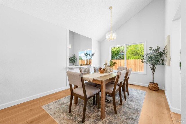 225 Riverview Dr, Vallejo, CA 94589 - dining area with a chandelier, baseboards, high vaulted ceiling, and light wood-style flooring