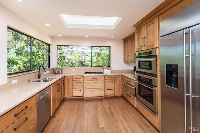 1043 La Quinta Ct, Napa, CA 94559 - kitchen with stainless steel appliances, a sink, light wood finished floors, light countertops, and a skylight