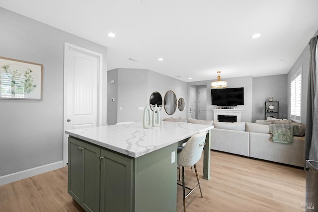 840 Allegro Ct, Fairfield, CA 94534 - kitchen with green cabinets, light wood-style flooring, a kitchen breakfast bar, a kitchen island, and light stone counters