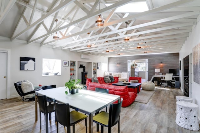 1067 Darms Ln, Napa, CA 94558 - dining area featuring a wall unit AC, a wood stove, wood finished floors, an office area, and high vaulted ceiling