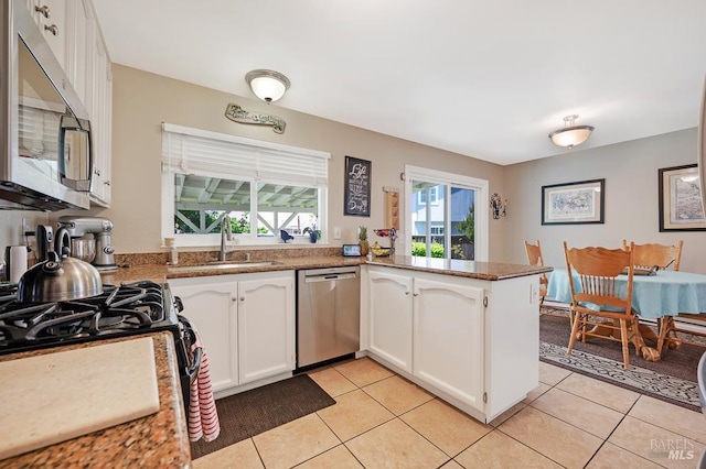 1405 Montana Pl, Rohnert Park, CA 94928 - kitchen with stainless steel appliances, a sink, white cabinetry, light tile patterned floors, and a peninsula