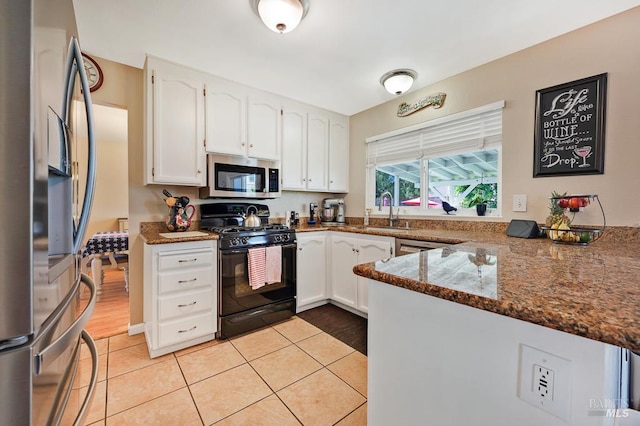 1405 Montana Pl, Rohnert Park, CA 94928 - kitchen with appliances with stainless steel finishes, a sink, white cabinets, dark stone counters, and a peninsula