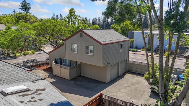 50 S A St, Santa Rosa, CA 95401 - view of side of home featuring a garage, roof with shingles, asphalt driveway, and stucco siding