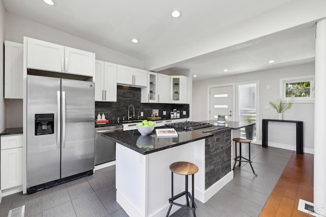 1131 W California Ave, Mill Valley, CA 94941 - kitchen featuring stainless steel appliances, decorative backsplash, a kitchen bar, a center island, and white cabinets