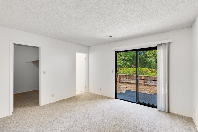 2000 Clearview Cir, Benicia, CA 94510 - unfurnished bedroom featuring access to exterior, carpet flooring, a textured ceiling, and a walk in closet