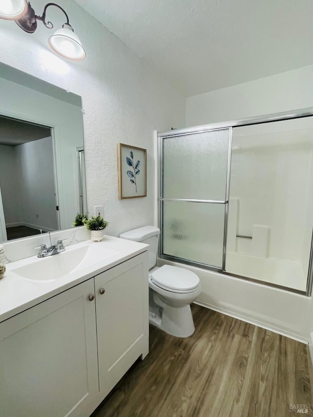 225 Pennsylvania Ave Unit B1, Fairfield, CA 94533 - full bath with wood finished floors, vanity, a textured wall, toilet, and combined bath / shower with glass door