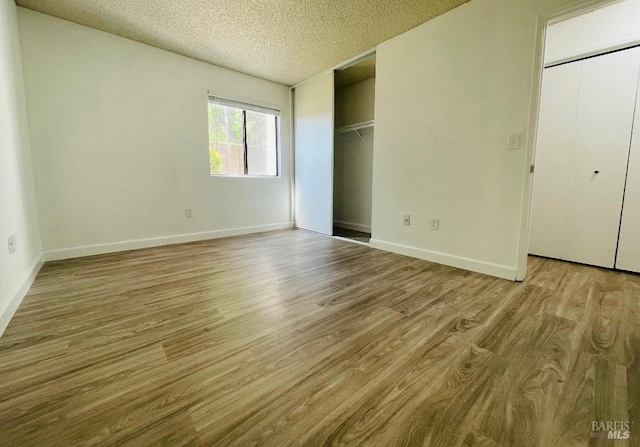 225 Pennsylvania Ave Unit B1, Fairfield, CA 94533 - unfurnished bedroom with wood finished floors, a textured ceiling, and baseboards