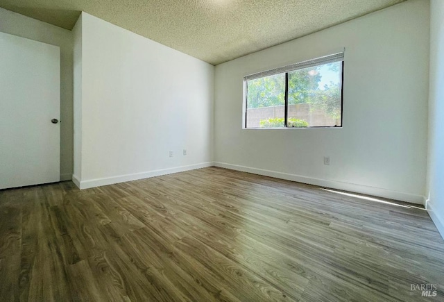 225 Pennsylvania Ave Unit B1, Fairfield, CA 94533 - empty room featuring wood finished floors, a textured ceiling, and baseboards