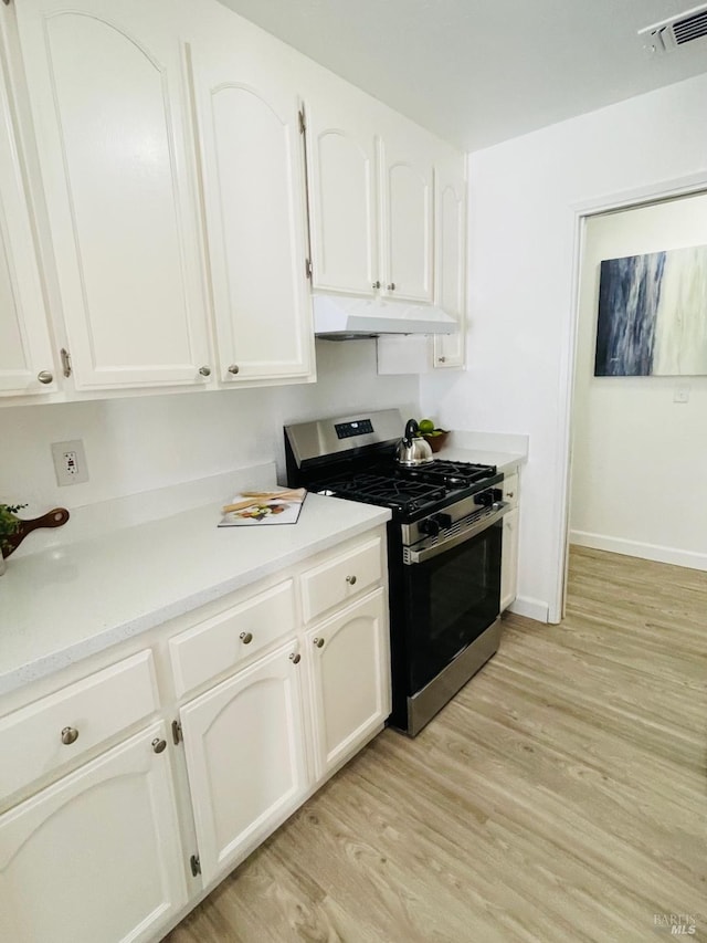225 Pennsylvania Ave Unit B1, Fairfield, CA 94533 - kitchen featuring stainless steel range with gas cooktop, under cabinet range hood, light wood-type flooring, white cabinets, and light countertops