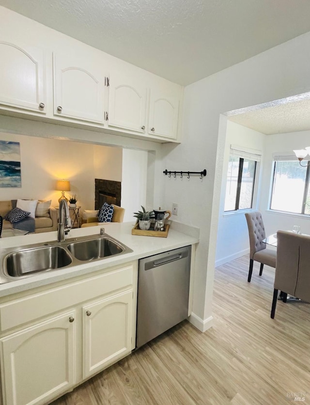 225 Pennsylvania Ave Unit B1, Fairfield, CA 94533 - kitchen with stainless steel dishwasher, a sink, light wood finished floors, light countertops, and a textured ceiling