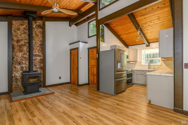 45270 Ocean View Ln, Gualala, CA 95445 - kitchen featuring appliances with stainless steel finishes, wood ceiling with exposed beams, a wood stove, light countertops, and a ceiling fan