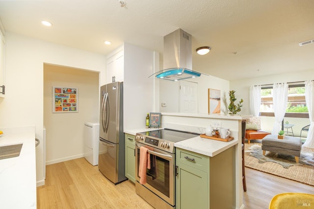 8201 Camino Colegio Unit 17, Rohnert Park, CA 94928 - kitchen featuring stainless steel appliances, island range hood, green cabinets, and light wood finished floors