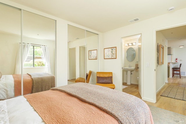 8201 Camino Colegio Unit 17, Rohnert Park, CA 94928 - bedroom with light wood-style flooring, multiple closets, a sink, ensuite bath, and baseboards
