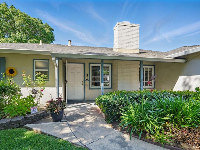 1233 Lincoln St, Fairfield, CA 94533 - doorway to property featuring a chimney, roof with shingles, stucco siding, and brick siding