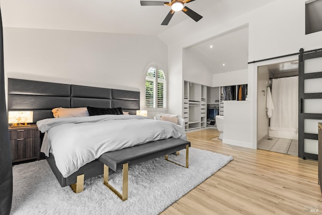 9508 Jessica Dr, Windsor, CA 95492 - bedroom featuring a barn door, vaulted ceiling, light wood-type flooring, baseboards, and ceiling fan