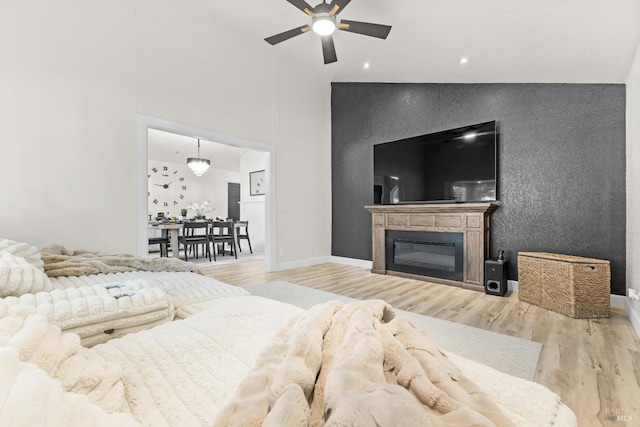 9508 Jessica Dr, Windsor, CA 95492 - living room featuring ceiling fan, wood finished floors, a high ceiling, a glass covered fireplace, and baseboards