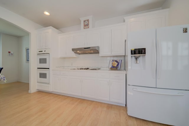 3543 Oak Shores Dr, Stockton, CA 95209 - kitchen featuring white appliances, under cabinet range hood, white cabinets, light wood-style floors, and decorative backsplash