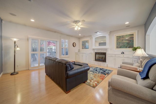3543 Oak Shores Dr, Stockton, CA 95209 - living room featuring a ceiling fan, light wood-type flooring, a tiled fireplace, baseboards, and recessed lighting
