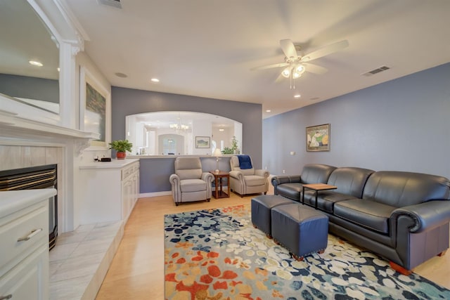 3543 Oak Shores Dr, Stockton, CA 95209 - living room featuring arched walkways, a ceiling fan, recessed lighting, a fireplace, and light wood-type flooring