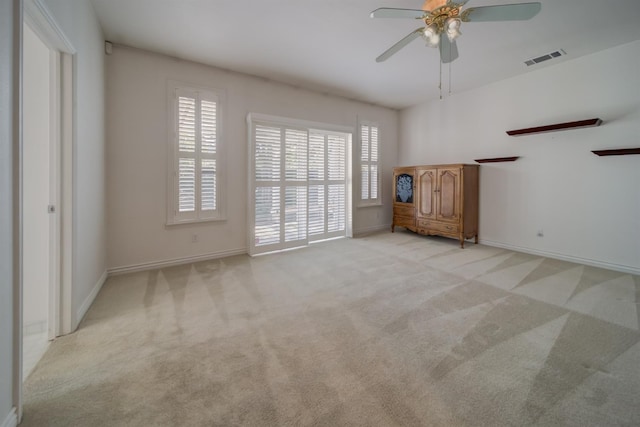 3543 Oak Shores Dr, Stockton, CA 95209 - unfurnished living room featuring a ceiling fan, light carpet, baseboards, and plenty of natural light