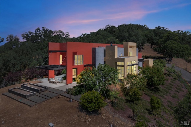48 Longhorn Ridge Rd, Napa, CA 94558 - back of house at dusk featuring a patio area, stucco siding, and a balcony
