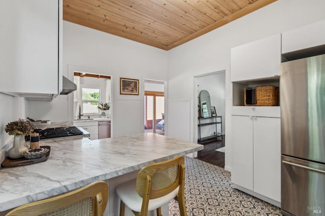 516 Howard St, Petaluma, CA 94952 - kitchen with freestanding refrigerator, white cabinetry, wooden ceiling, a kitchen breakfast bar, and a peninsula