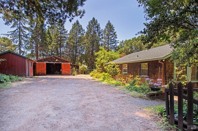 15866 Wright Dr, Guerneville, CA 95446 - view of property exterior with an outbuilding, driveway, and roof with shingles