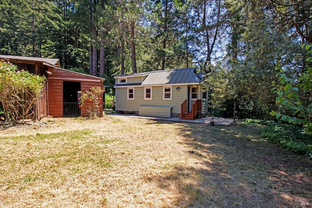 15866 Wright Dr, Guerneville, CA 95446 - back of house with a lawn, metal roof, an outdoor structure, and entry steps