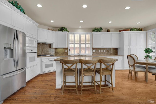 116 Birmingham Ct, Discovery Bay, CA 94505 - kitchen with white appliances, recessed lighting, white cabinets, a center island, and tasteful backsplash