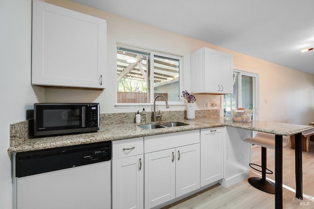 725 Lytton Station Rd, Healdsburg, CA 95448 - kitchen featuring white dishwasher, black microwave, a sink, light wood-style floors, and white cabinetry