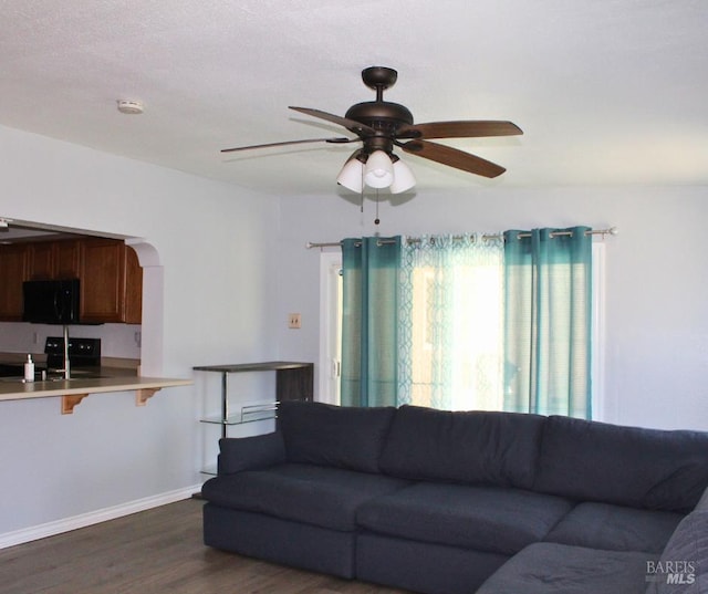 1863 Mini Dr, Vallejo, CA 94589 - living room with dark wood-style flooring, ceiling fan, baseboards, and arched walkways